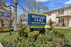 Norristown apartment for rent - A sign for West Gate Arms Apartment Homes sits in front of a building.
