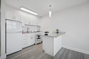 Philadelphia apartment for rent - A white kitchen with a refrigerator, stove, and sink.