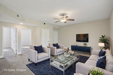 Overland Park apartment for rent - A living room with a glass coffee table and a blue rug.