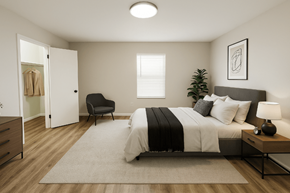 Overland Park apartment for rent - A bedroom with a bed, chair, and a plant.