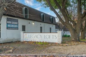 Dallas apartment for rent - A white building with a sign that says "Legacy Lofts" is for lease.