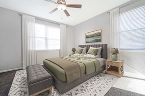 Overland Park apartment for rent - A bedroom with a large bed and a ceiling fan.