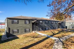 Grandview apartment for rent - A large grey building with a brown roof and a white walkway in front.