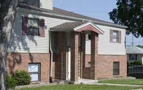 Grandview apartment for rent - A house with a white siding and a brick facade with a brown door.