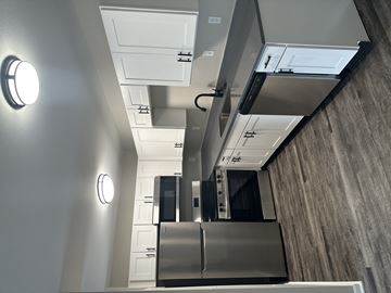 Kansas City apartment for rent - A modern kitchen with a stainless steel refrigerator and a wall-mounted oven.