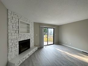 Overland Park apartment for rent - an empty living room with a stone fireplace