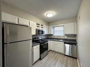 Overland Park apartment for rent - a kitchen with white cabinets and stainless steel appliances