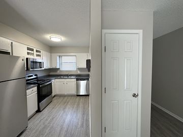 Overland Park apartment for rent - an empty kitchen with stainless steel appliances and white cabinets