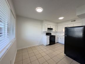 Arlington apartment for rent - A kitchen with black appliances and white cabinets.