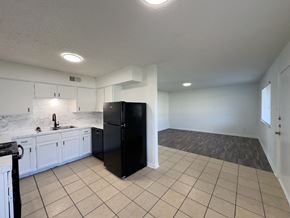 Arlington apartment for rent - A black refrigerator in a kitchen with white cabinets and a marble backsplash.