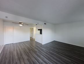 Dallas apartment for rent - A room with a ceiling fan and wooden flooring.