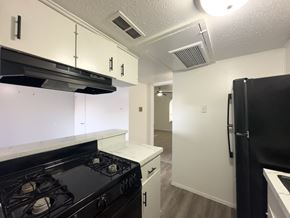 Dallas apartment for rent - A kitchen with black appliances and white cabinets.