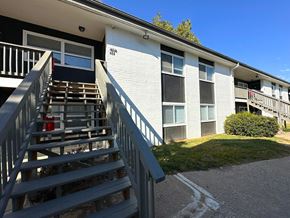 Riverside apartment for rent - an exterior view of a building with wooden stairs