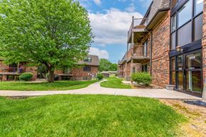 Lee's Summit apartment for rent - a grassy area with trees and buildings in the background