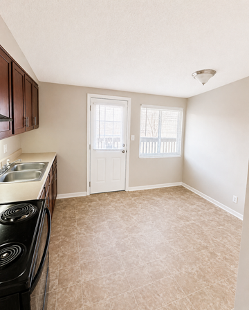 Leavenworth apartment for rent - A kitchen with a black stove top oven and a white door.
