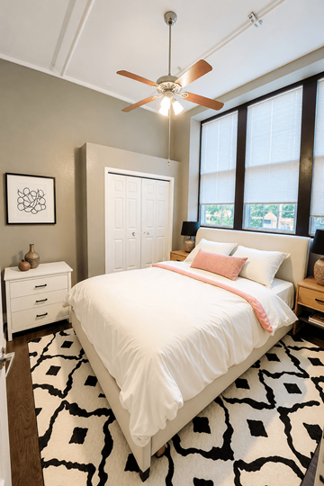 Ottawa apartment for rent - A bedroom with a white bed and a black and white rug.