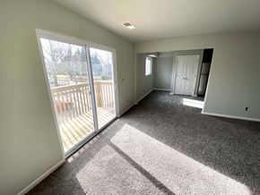 Kansas City apartment for rent - A sunny day with a carpeted room and sliding glass doors.