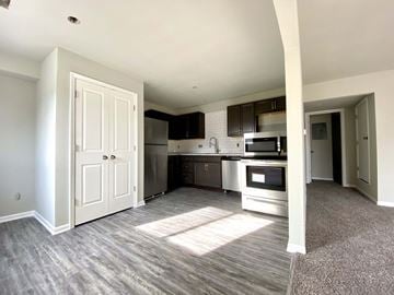 Kansas City apartment for rent - A kitchen with a white door and a microwave above the stove.