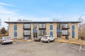 Kansas City apartment for rent - A parking lot with cars and a building in the background.