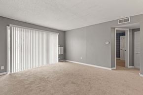 Kansas City apartment for rent - A room with a carpeted floor and a window with blinds.