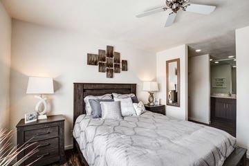 Overland Park apartment for rent - A bedroom with a large bed and a ceiling fan.