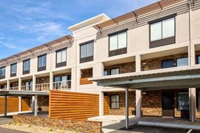 Overland Park apartment for rent - A modern building with a combination of stone and wood materials.