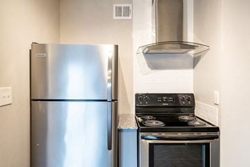 Gladstone apartment for rent - A stainless steel refrigerator and stove top oven in a kitchen.