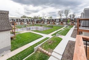 Gladstone apartment for rent - A view of a courtyard with a grassy area and a fence.