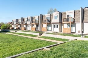 Gladstone apartment for rent - A row of modern townhouses with green lawns in front.