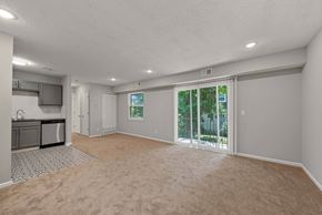 Blue Springs apartment for rent - A spacious room with a carpeted floor and sliding glass doors leading to a backyard.