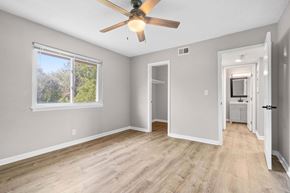 Gladstone apartment for rent - A room with a ceiling fan and a window with trees visible outside.