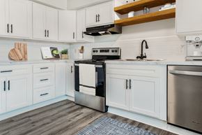 Overland Park apartment for rent - A modern kitchen with white cabinets and a stainless steel oven.