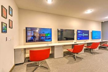 A room with three televisions on the wall
