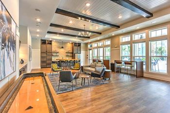 A large room with couches and chairs and a pool table