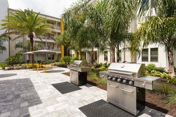 Two grills in a courtyard with a building in the background