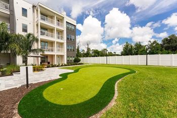 A grassy area in front of an apartment building