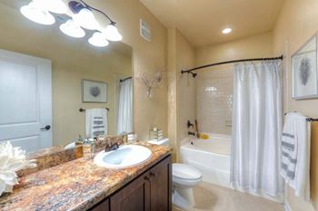 A bathroom with a sink toilet and bathtub