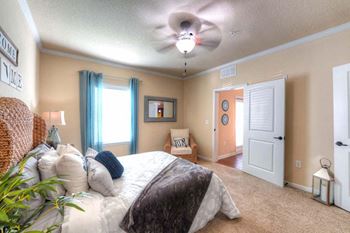 A bedroom with a bed and a ceiling fan