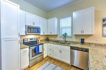 A kitchen with a stove top oven next to a window
