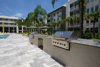 A kitchen with a stove top oven next to a swimming pool