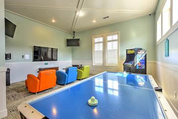 A room with a ping pong table and a television