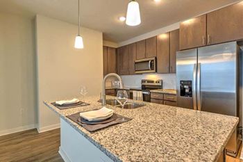 A kitchen with a large counter top next to a refrigerator
