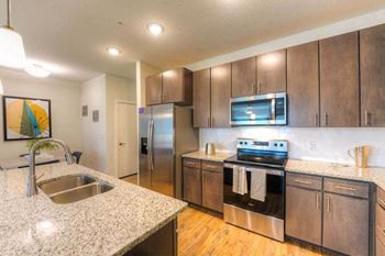 A kitchen with a sink stove and refrigerator