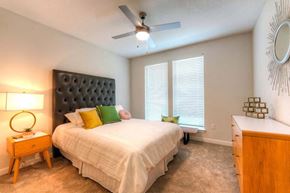 Jacksonville apartment for rent - a bedroom with a large bed and a ceiling fan  at Fusion, Jacksonville, 32256