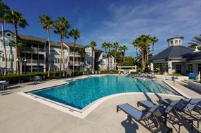 Jacksonville Beach apartment for rent - a large pool with chaise lounge chairs and palm trees in the background  at Ocean Park, Jacksonville Beach, Florida