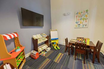 A room with a tv and a table and chairs