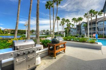 A barbecue grill sitting next to a table with a kettle on it