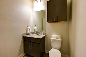 A bathroom with a sink toilet and mirror