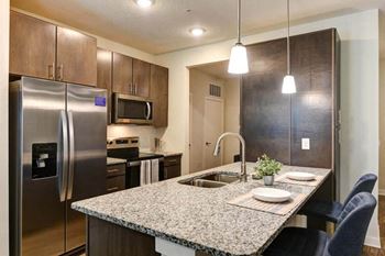 A kitchen with a sink a stove and a refrigerator