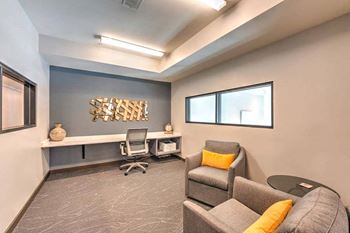 A room with a couch chair and desk in it